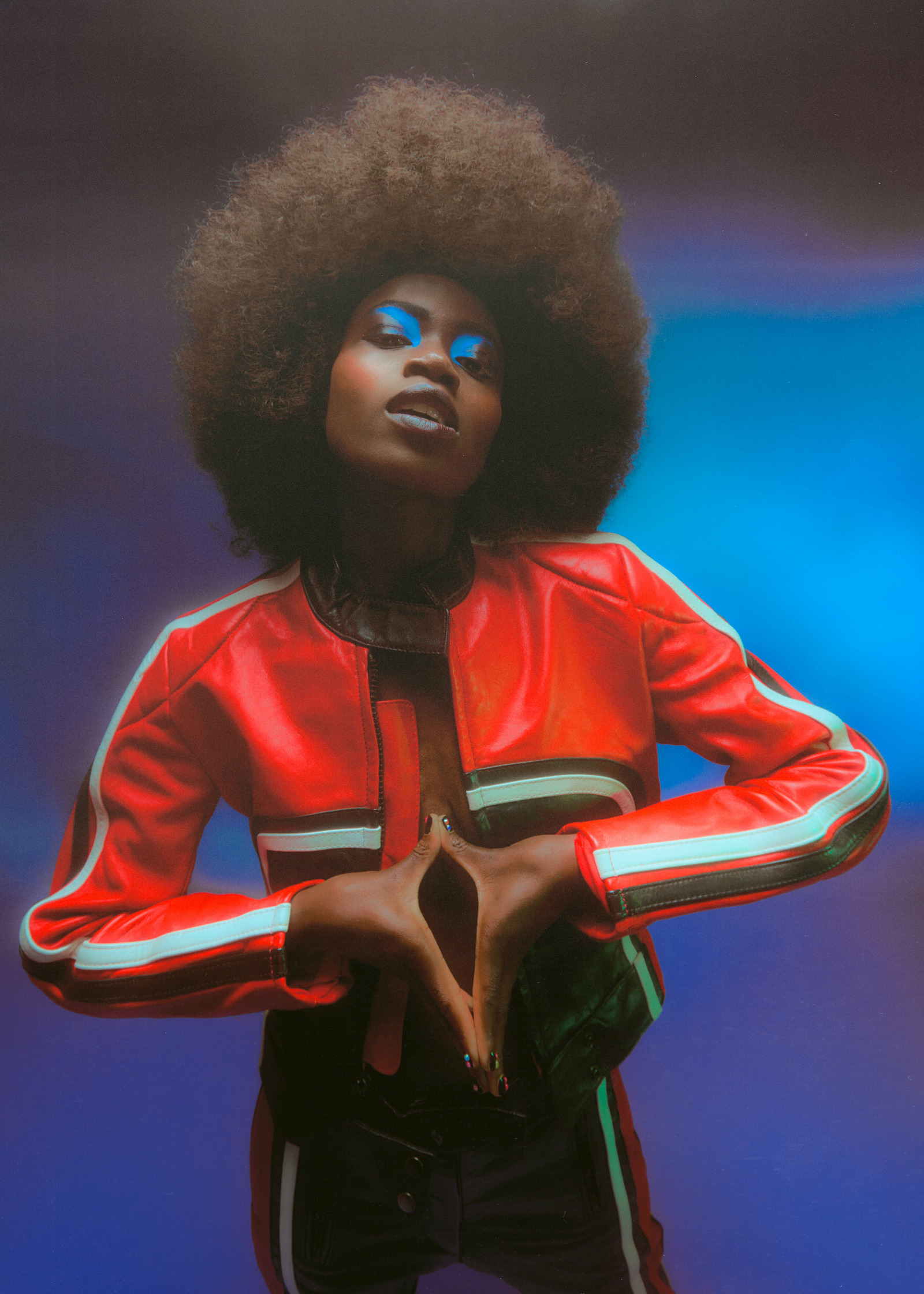 a woman with an afro in a red leather jacket