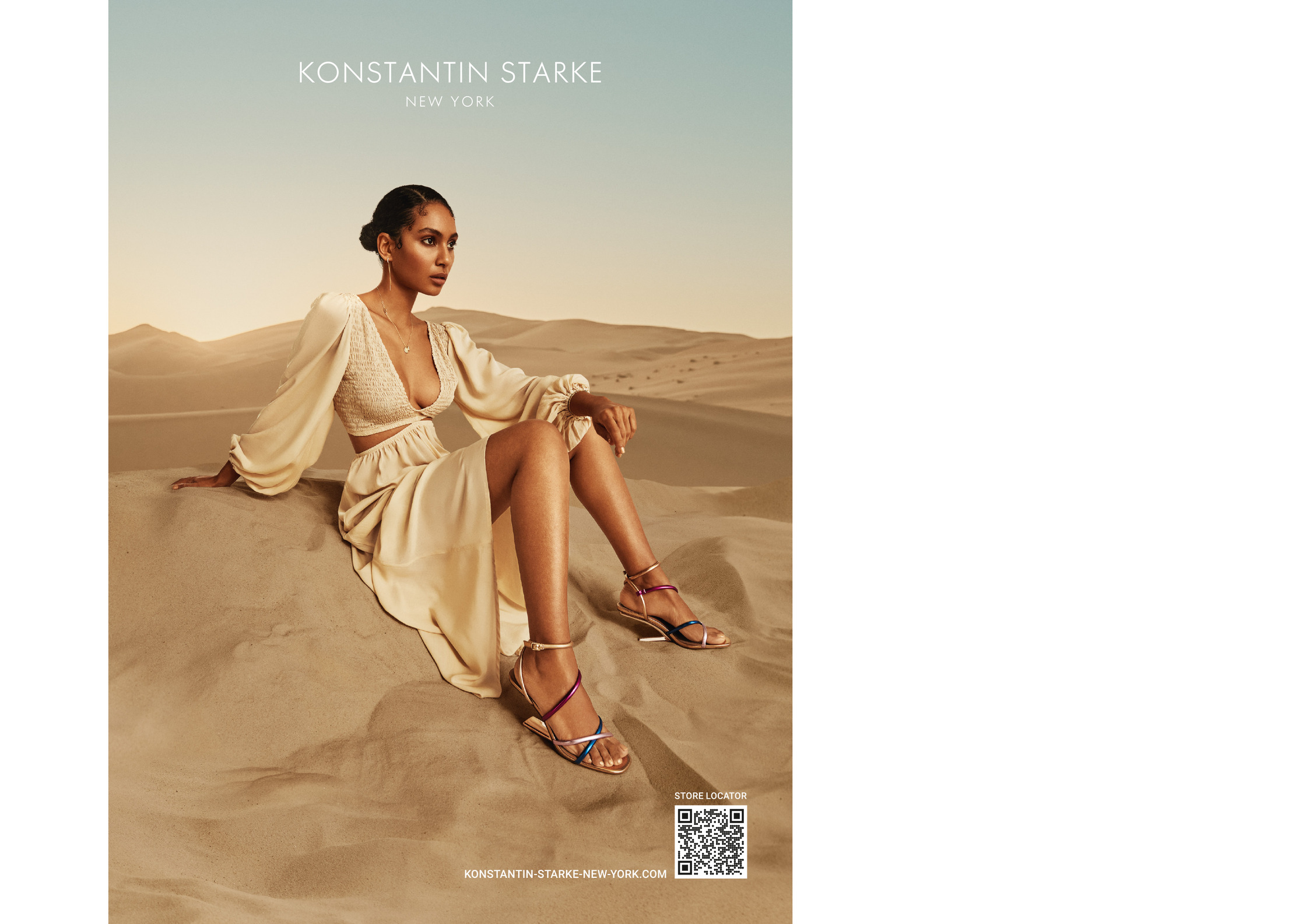 a woman in a dress sitting on a sand dune. advertising key visual for konstantin starke new york.