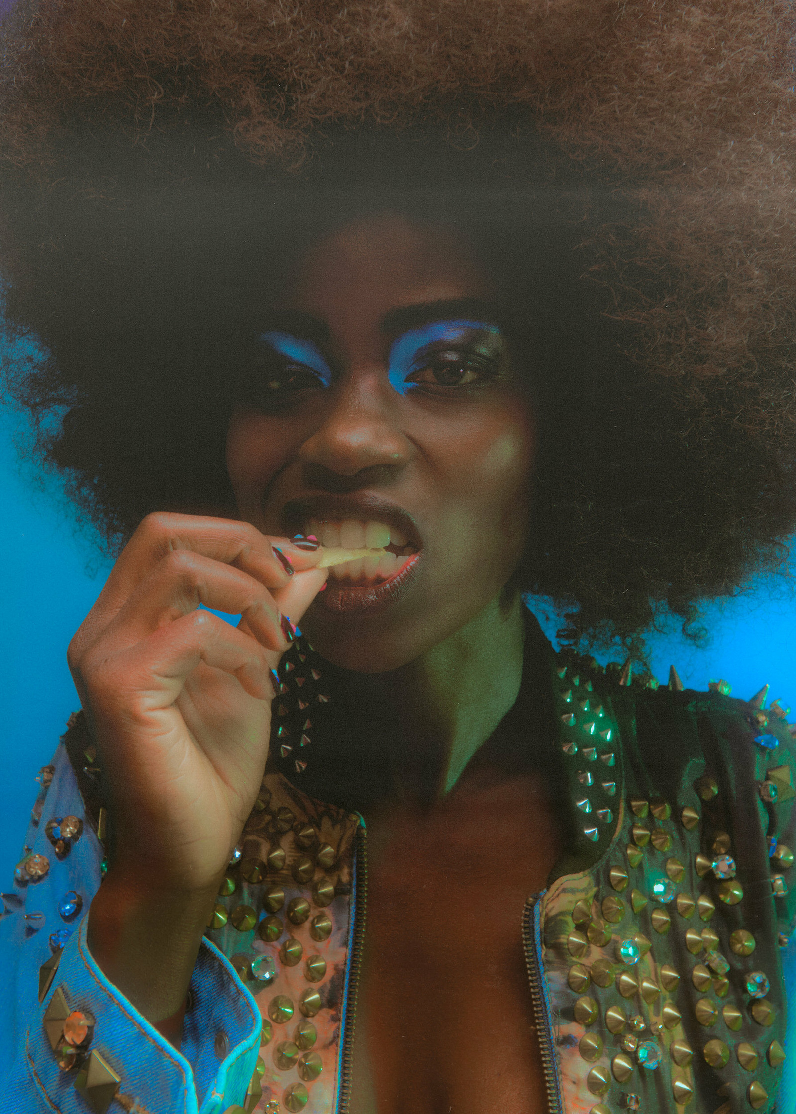 a woman with an afro is eating a piece of food