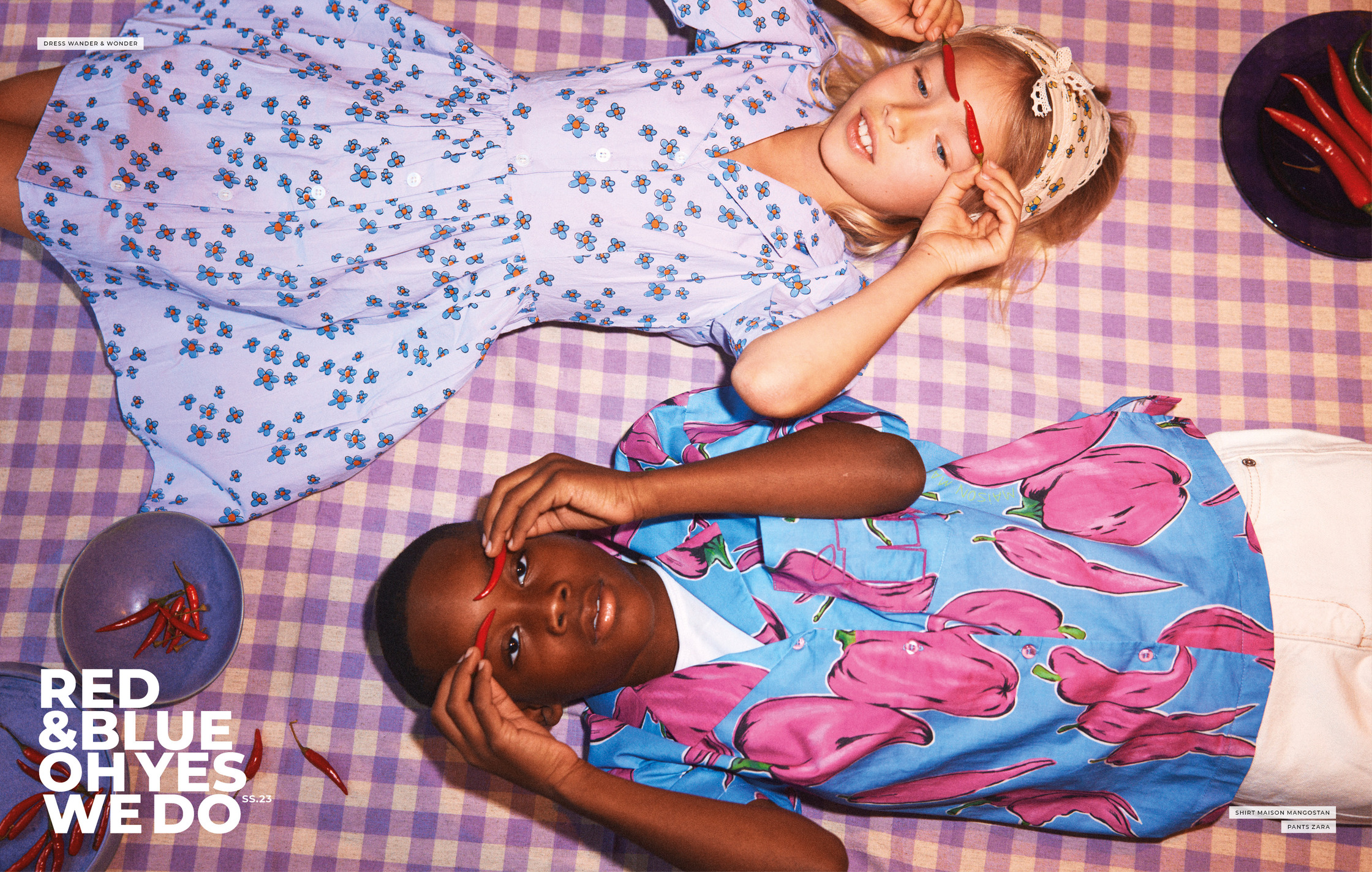 two children laying on a blanket with red and blue peppers