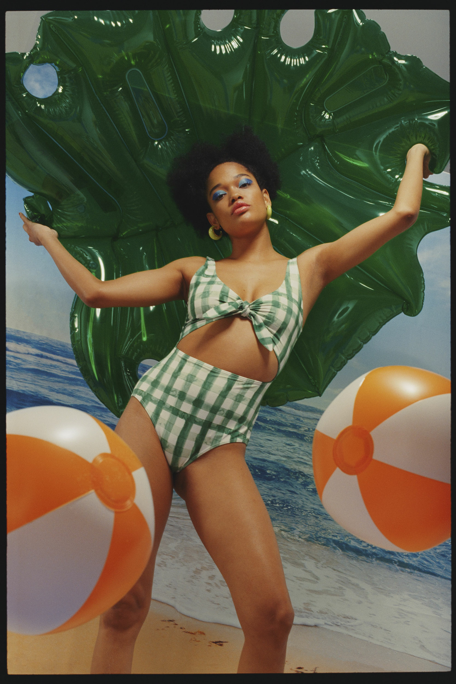 a woman in a green bikini posing with balloons