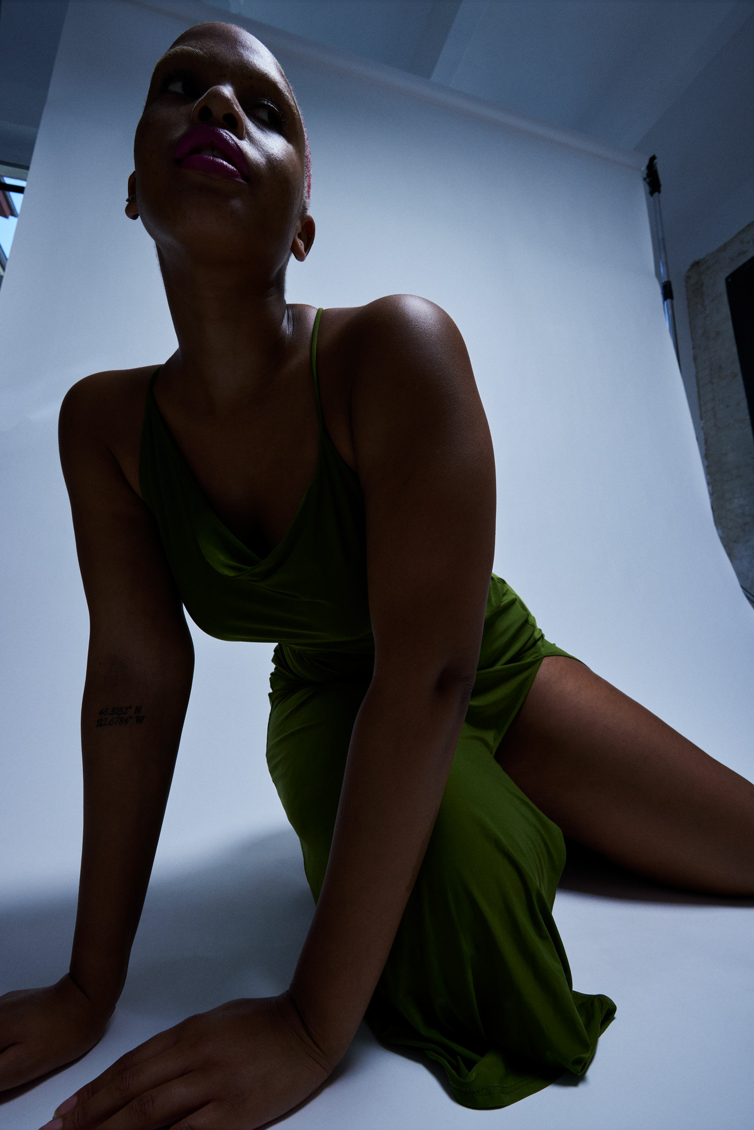a woman in a green dress posing in a studio  Una Mabasa  by fashionphotographer Frauke Fischer 