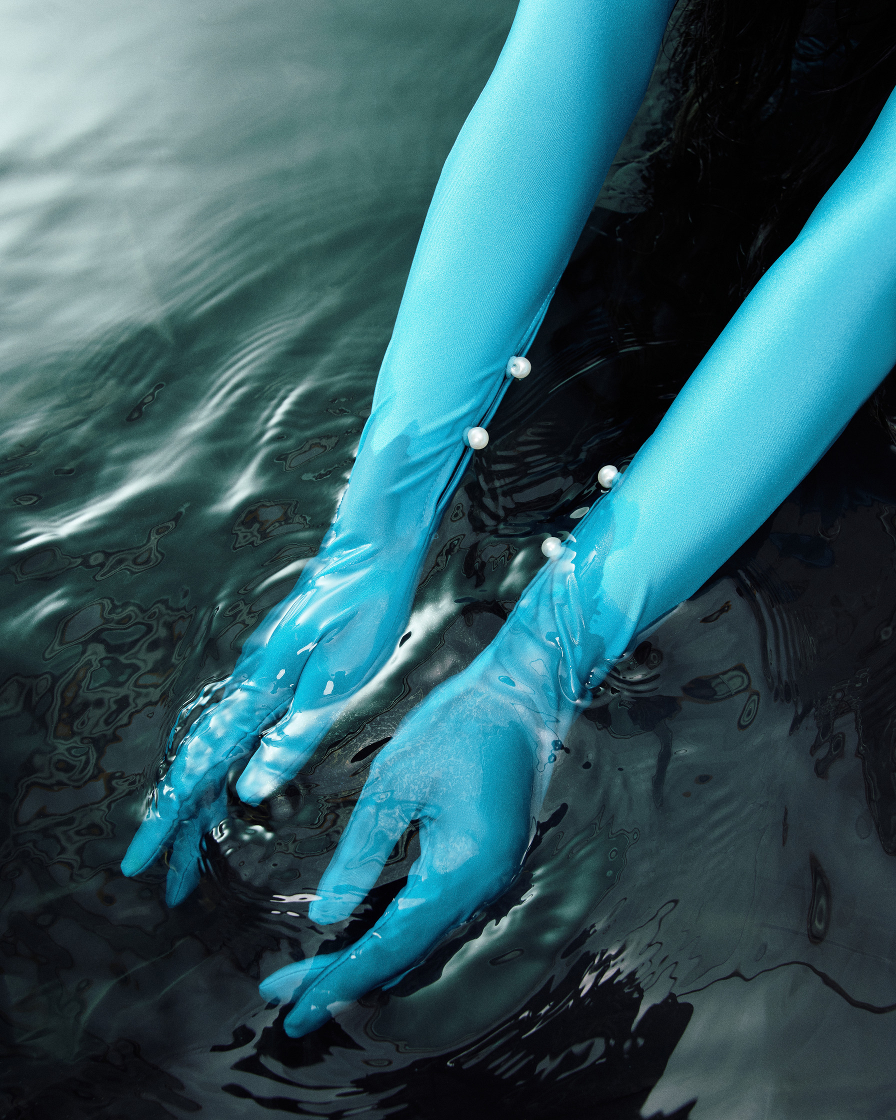 a woman wearing blue gloves in the water
