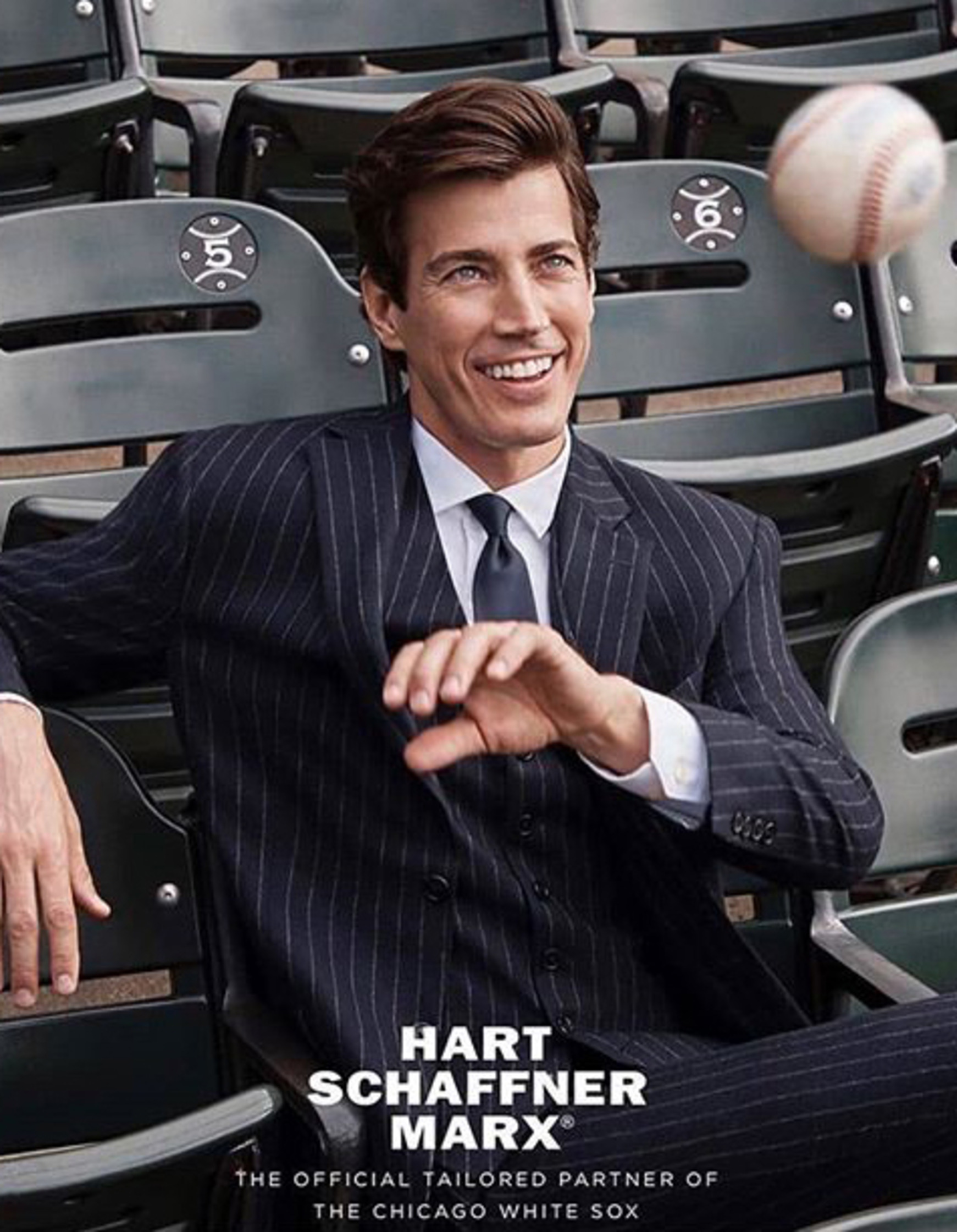 a man in a suit sitting on a baseball field