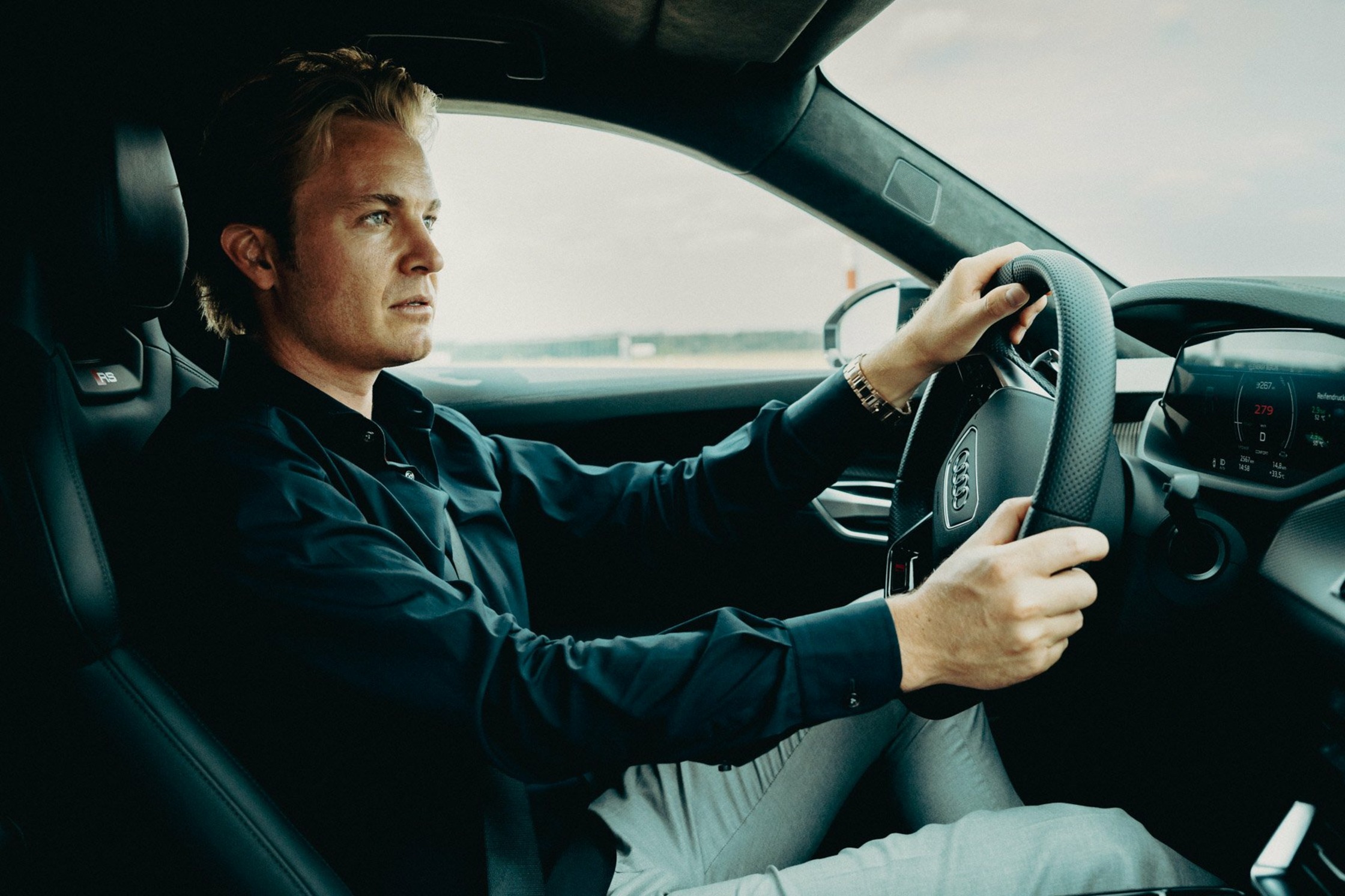 a man sitting in the driver's seat of a car nico rosberg audi e-tron