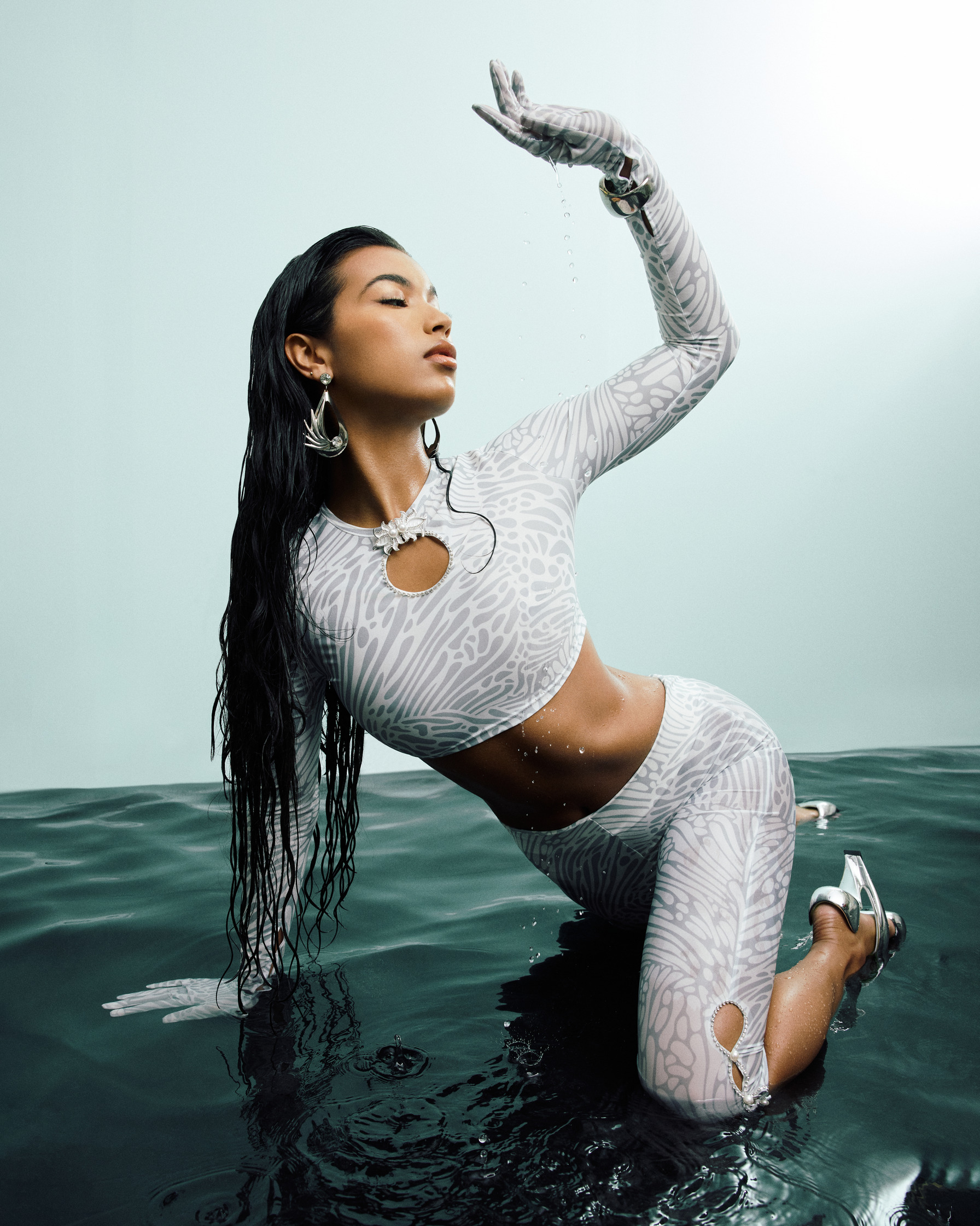 a woman in a white outfit posing in water