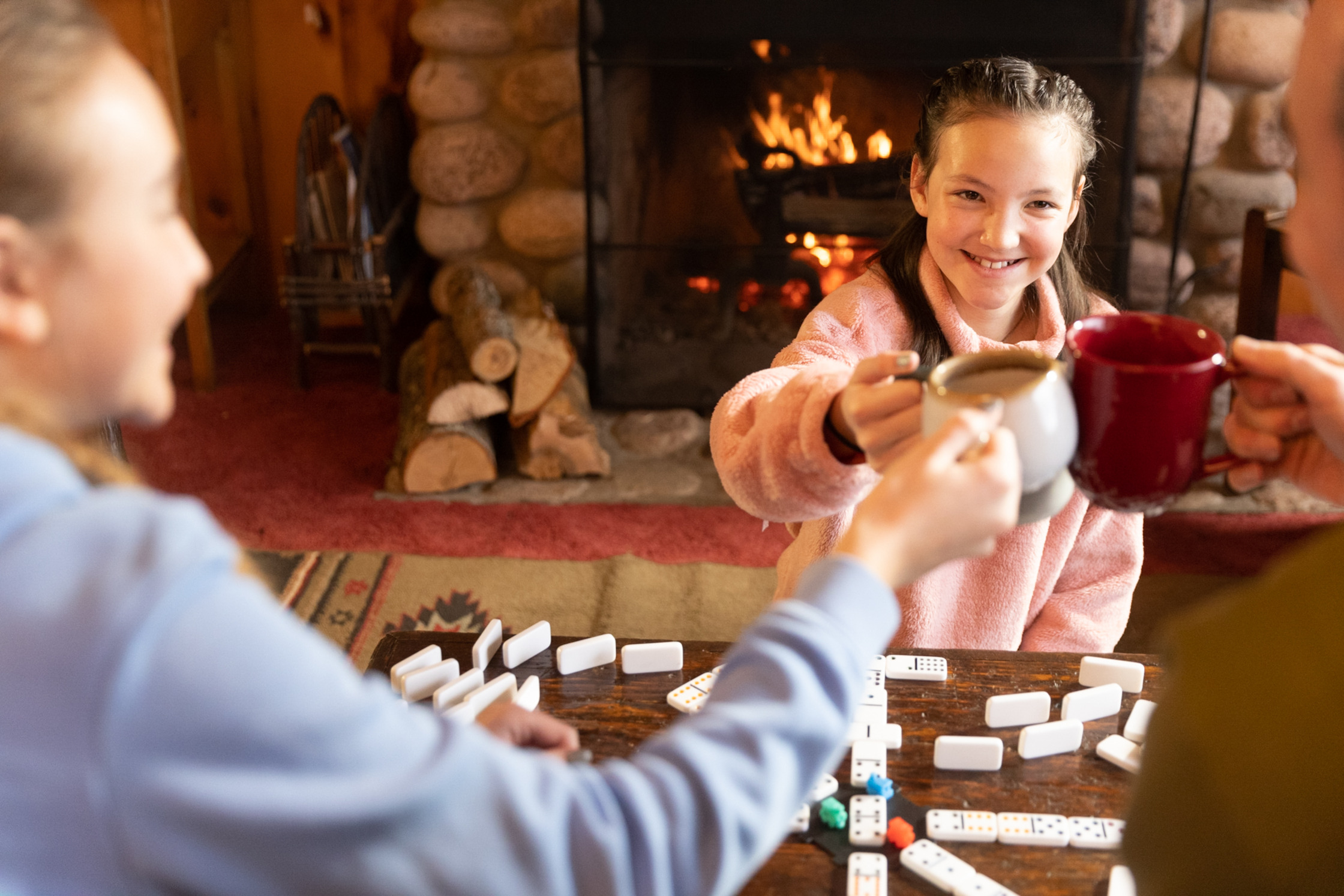 a family playing a game of dominoes in front of a fireplace