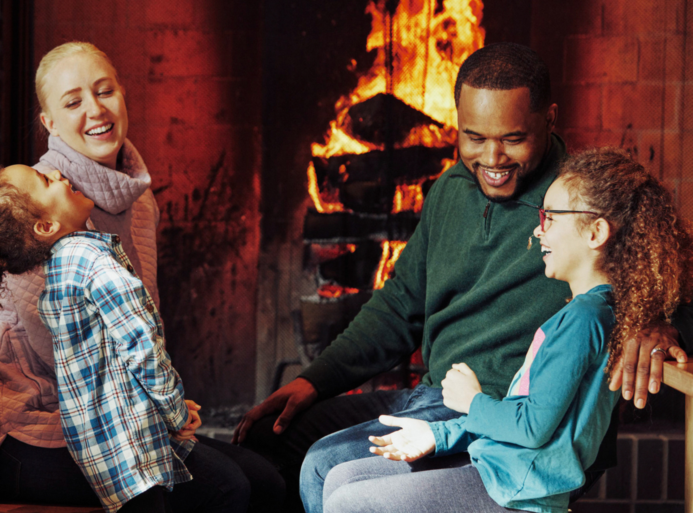 a family sitting in front of a fireplace