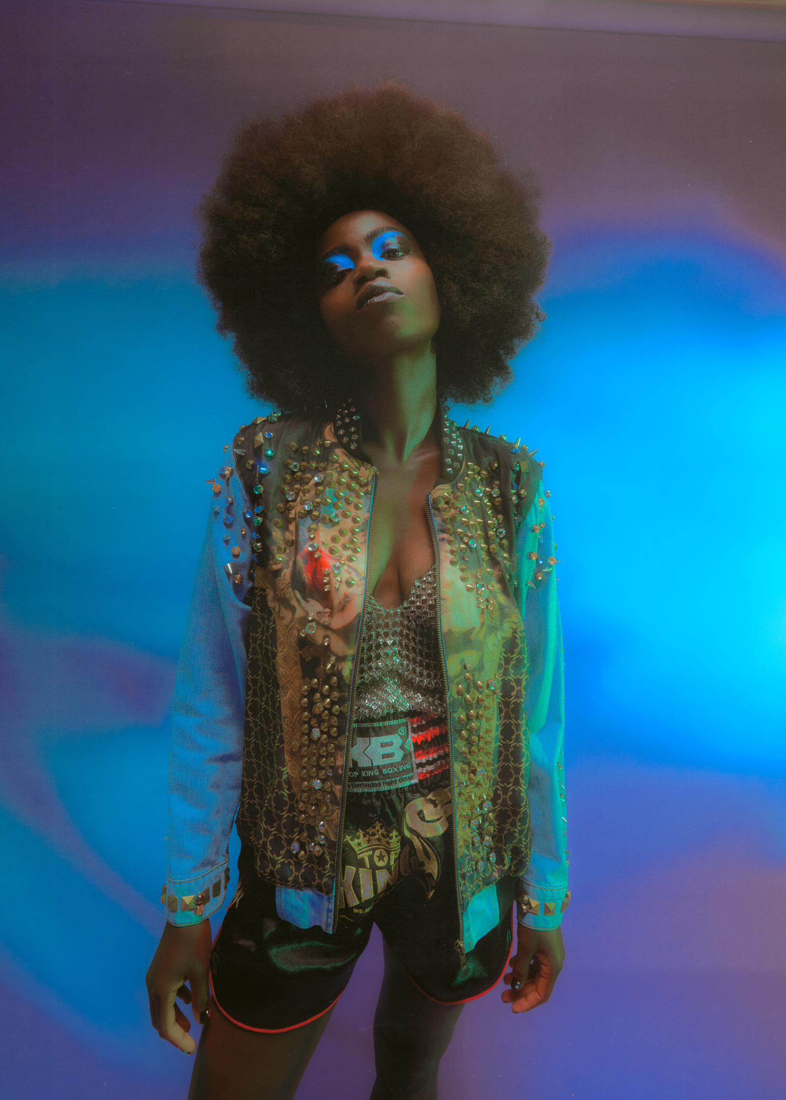 a woman with an afro posing in front of a blue light