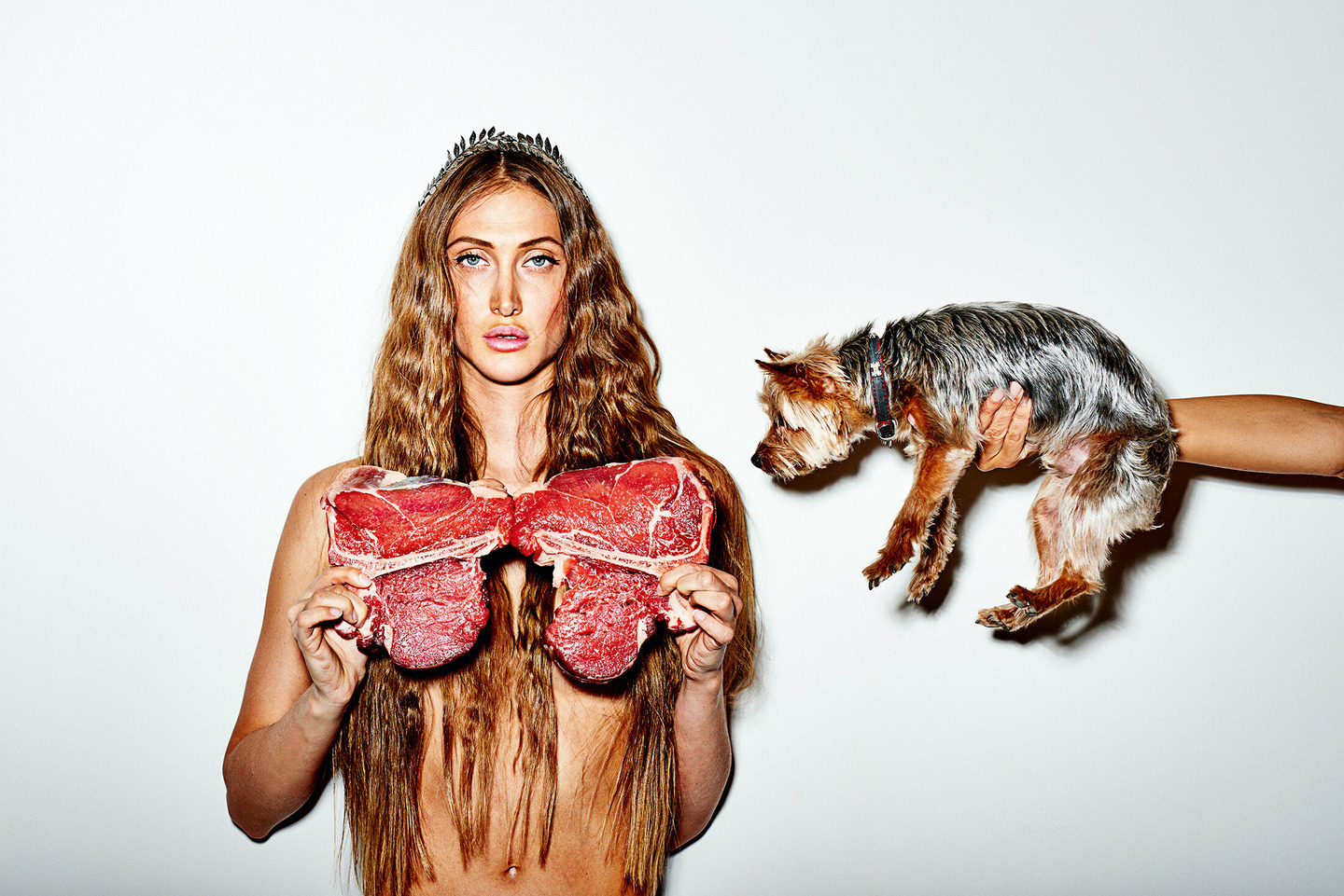 a woman with long hair holding a piece of meat