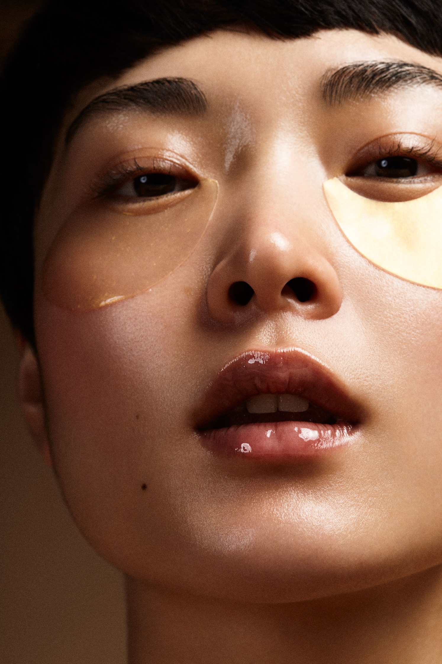 beauty close-up photo of an asian woman with skincare eyepatches  and glossy lipstick by Berlin based photographer Frauke Fischer
