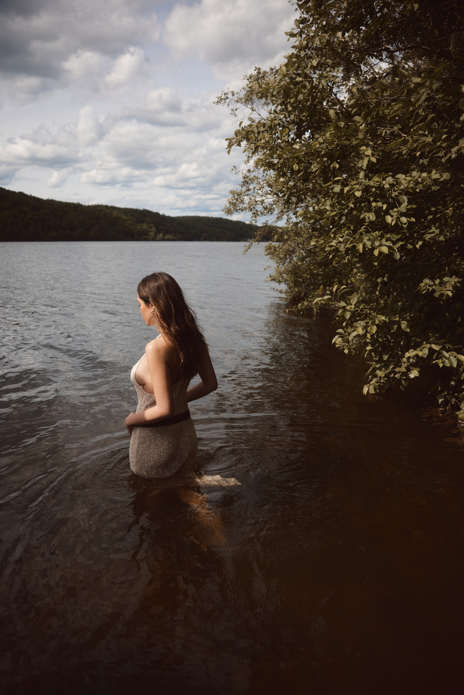 a woman is standing in the water of a lake