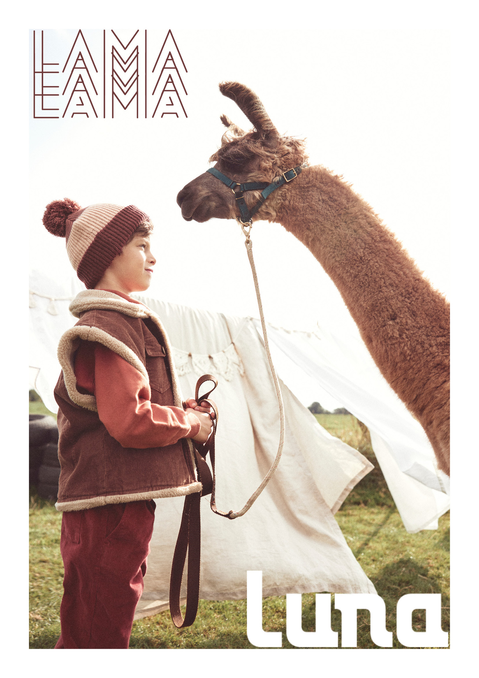 a young boy is standing next to a llama