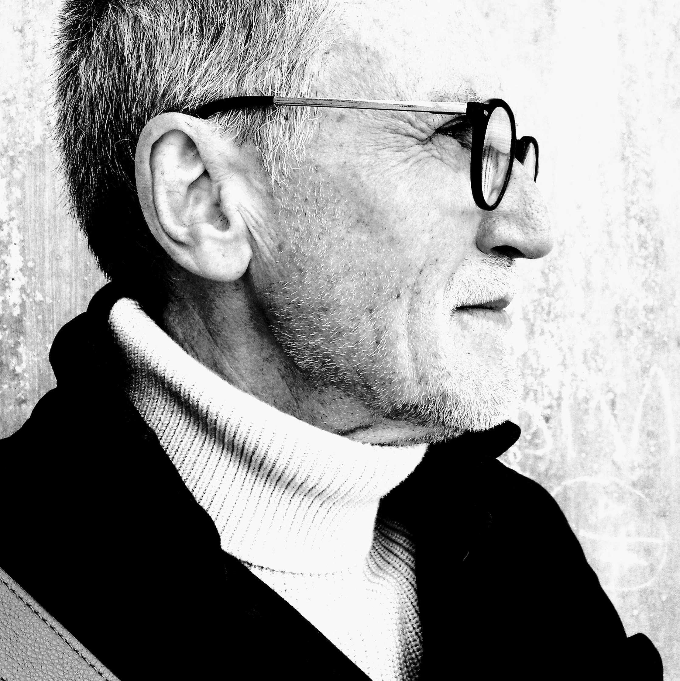 a black and white photo of an older man wearing glasses