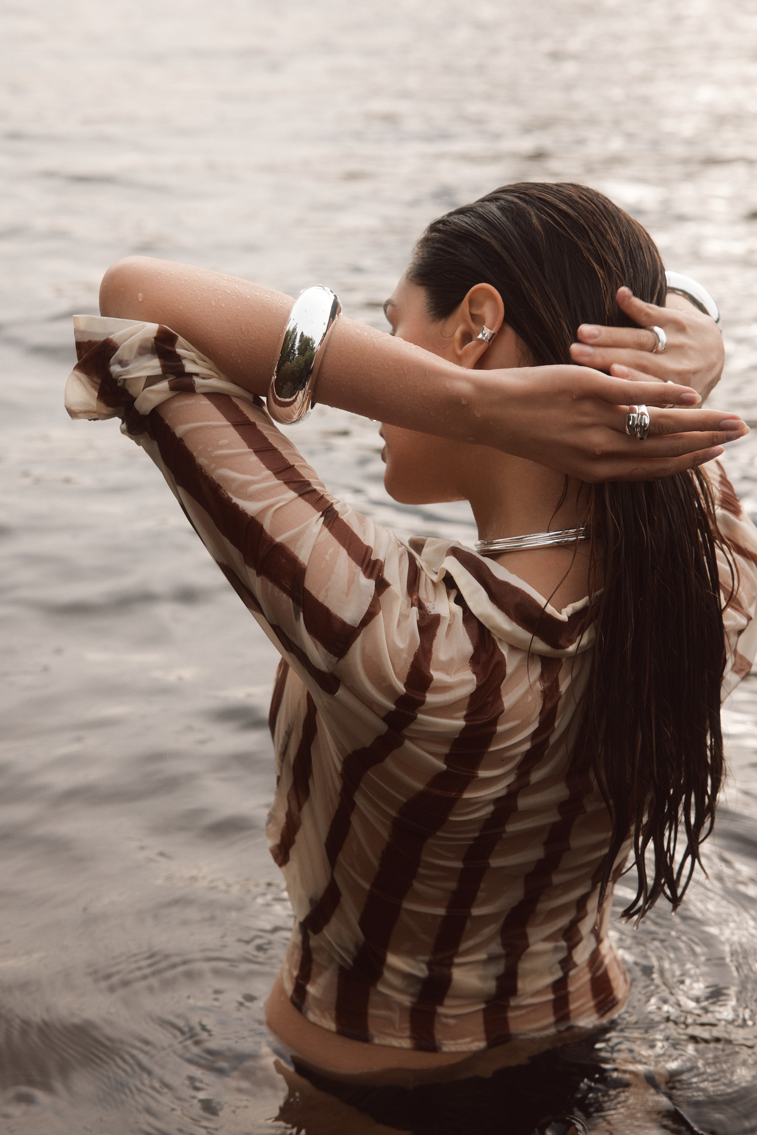 a woman in a striped shirt standing in the water