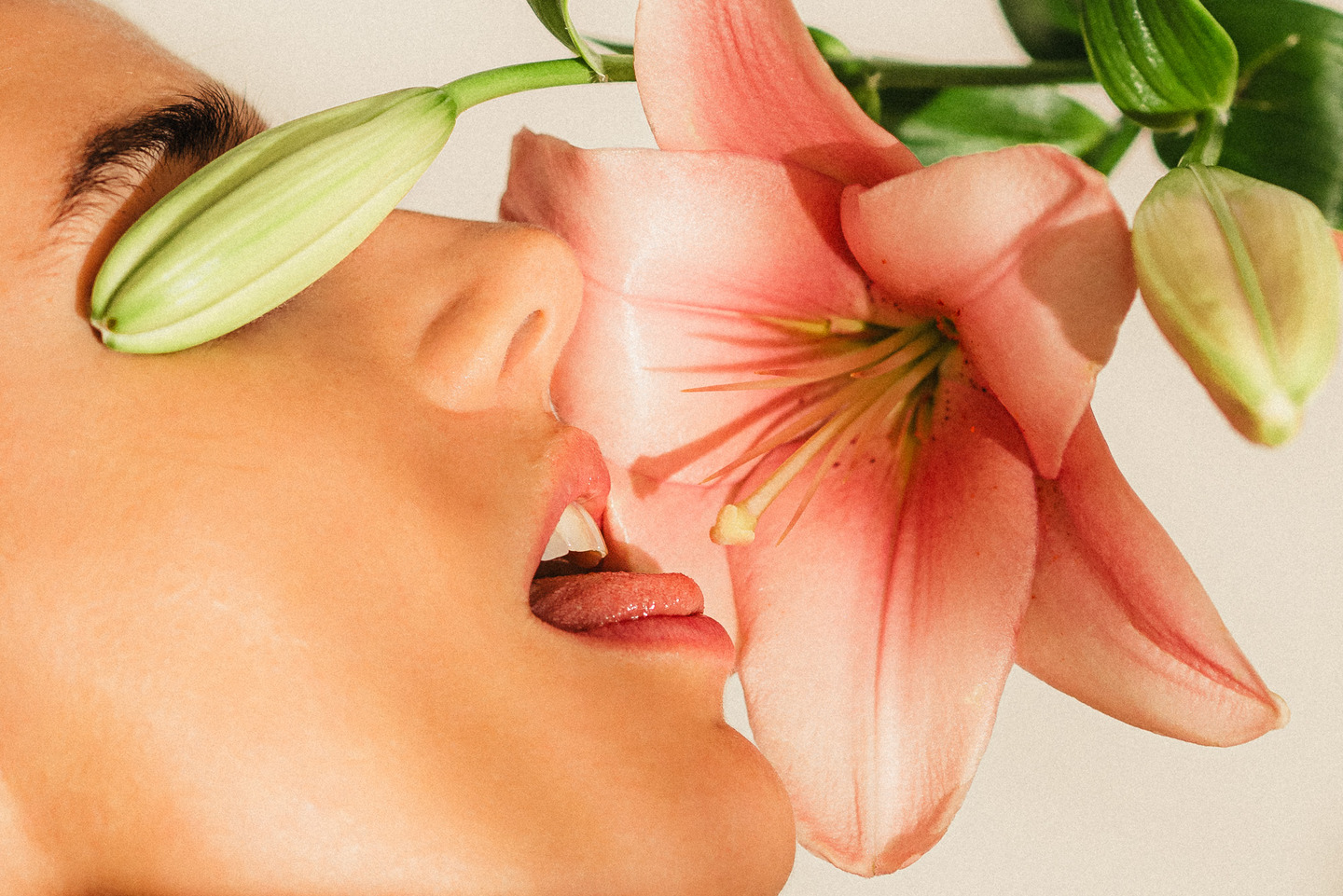 a woman is smelling a flower