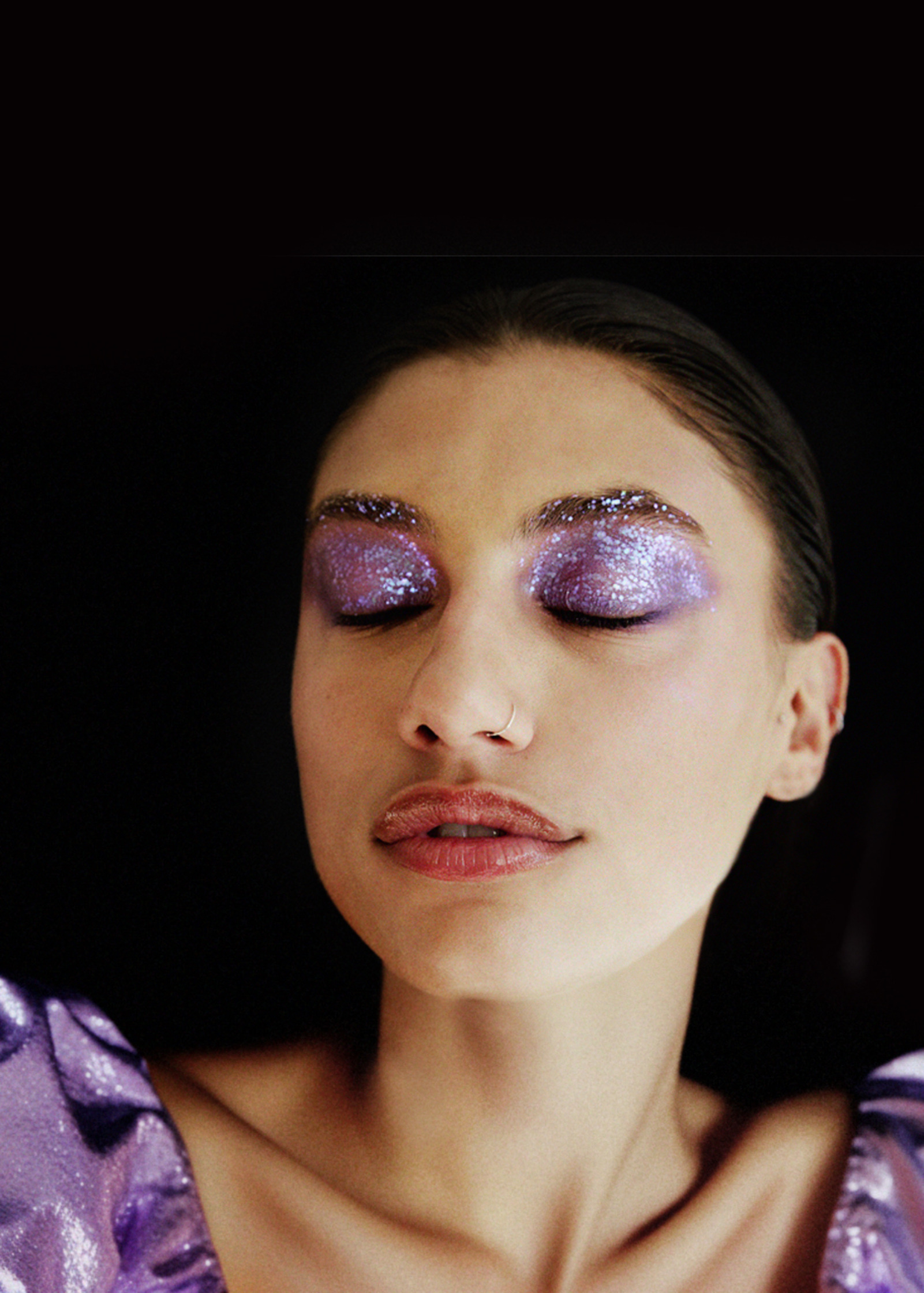 a woman in a purple dress with purple eye makeup