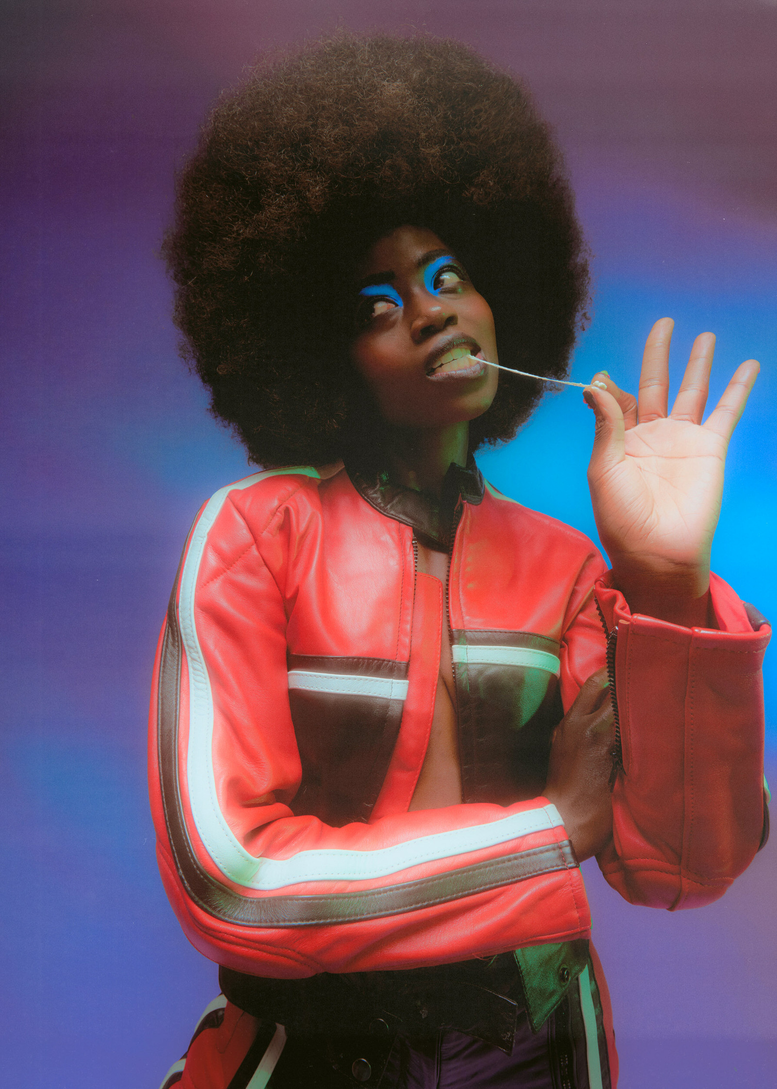 a woman with an afro wearing a red jacket